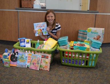Addy Riemer with the toys and books she collected for charity on her birhday
