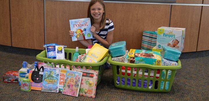 Addy Riemer with the toys and books she collected for charity on her birhday