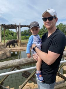 Little boy and dad posed in front of the elephant exhibit