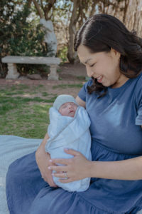 Mother tenderly cradling a swaddled baby