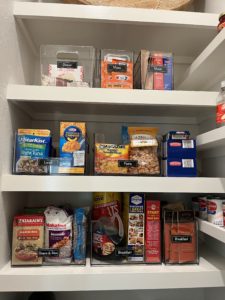 An organized kitchen pantry with snacks and breakfast food on display.