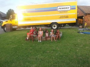 The author's family posing in front of a yellow moving truck.