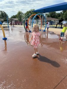 A toddler having fun at a splash pad on a sunny day. Splash pads are a free and fun way for little kids to beat the heat. 