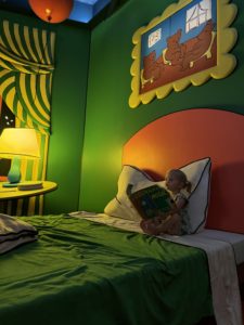 A little girl reading "Good Night Moon" in the Good Night Moon room at the Rabbit Hole in Kansas City
