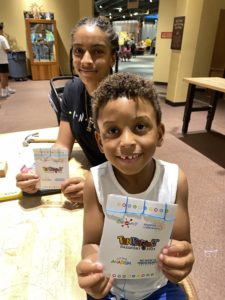 Two kids showing their STEAM work from Tinkerfest at Science Museum Oklahoma