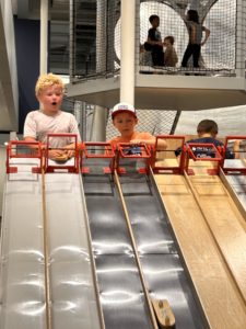 Kiddos posing at the top of a slide at Discovery Lab in Tulsa