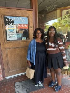 The author and her daughter standing outside the door for Edmond Antiques showing ways to support small businesses
