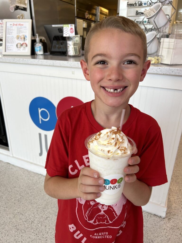 A smiling boy enjoys a sweet treat at Pie Junkie. 